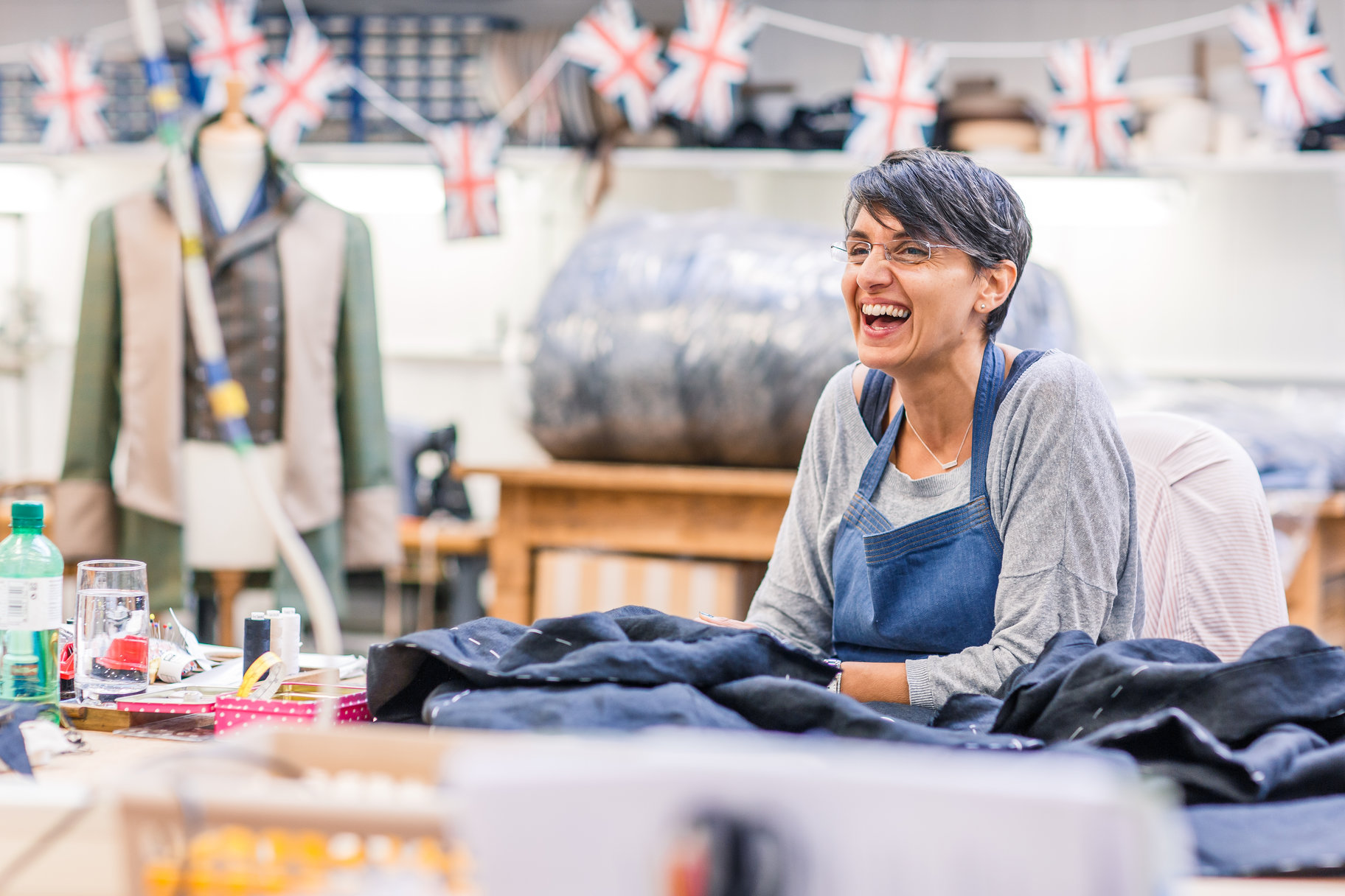 Woman in costume workshop laughing with fabric